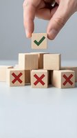 Hand placing wooden block with green checkmark on top of blocks with red X marks, symbolizing right choice and decision making.
