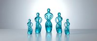 Turquoise glass figurines representing a family group, standing together on a reflective surface with soft gradient background.