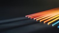 Colorful fiber optic cables arranged in rainbow spectrum against dark background create modern technological gradient effect for telecommunications concept.