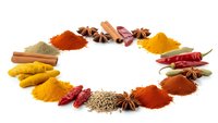 Colorful spices and herbs arranged in circular pattern on white background. Turmeric, paprika, cinnamon, star anise, chili peppers creating culinary frame.