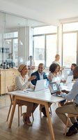 Diverse business team collaborating in modern office meeting room with laptops and digital security icons overlay for corporate technology solutions.