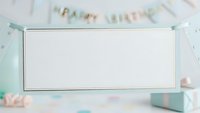 Mint green gift box with blank white label surrounded by pastel party decorations and confetti for birthday celebrations and special occasions.