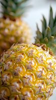 Fresh ripe pineapple close-up showing detailed yellow golden skin texture and geometric pattern, natural organic tropical fruit macro photography.