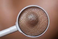 Close-up view of dark skin texture through magnifying glass showing pores, wrinkles and natural skin pattern detail in macro photography.