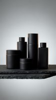 Black cosmetic containers and jars arranged on marble surface for luxury skincare and beauty product packaging design.
