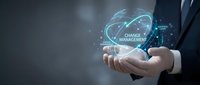 Professional businessman holding holographic change management concept with glowing digital interface and futuristic technology elements for business transformation.