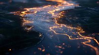 Aerial night view of illuminated city lights forming a network pattern across dark landscape, resembling flowing lava or digital circuitry.
