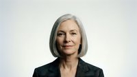 Mature woman with gray hair wearing black blazer, professional headshot on white background for corporate portraits and business profiles.