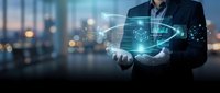 Professional businessman holding glowing digital technology hologram with futuristic interface elements and data visualization in modern office environment.