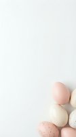 Pastel colored Easter eggs in soft pink beige and speckled patterns arranged on white background with copy space for spring holiday designs.