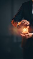 Businessman in dark suit holding glowing upward arrow chart icon between hands, representing financial growth, success, and business development strategy.