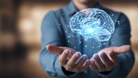 Businessman holding glowing digital brain hologram with neural networks and connections, representing artificial intelligence and innovation in technology.