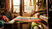 Traditional weaving loom with colorful textile in artisan workshop. Handcrafted fabric production, cultural heritage craft, authentic handmade process.