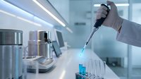 Laboratory scientist in white gloves using electronic pipette for precise liquid handling in modern research facility with test tubes and equipment.