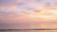 Serene ocean horizon at sunset with soft pink, purple, and golden sky reflecting on calm water, ideal for wellness and travel backgrounds.