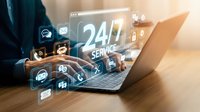 Professional using laptop with glowing 24/7 service icons and digital interface elements representing round-the-clock customer support and online assistance.