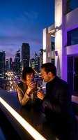 Romantic couple enjoying wine on luxury rooftop terrace with city skyline at twilight, celebrating anniversary or special occasion in urban setting.