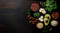Healthy plant-based protein sources arranged on dark wooden background with avocado, beans, nuts, and grains for vegan cooking.