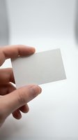 Hand holding blank white business card mockup template for branding and corporate identity design projects on neutral background.