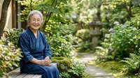 Senior Asian woman in traditional blue clothing sitting peacefully in lush garden setting with ivy-covered walls and stone pathway, suitable for wellness and lifestyle content.