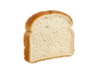 Single slice of white bread with golden crust isolated on white background, ready for food design, packaging, and culinary projects.