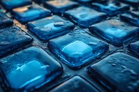 Macro view of blue glass tiles with water drops creating reflective surface and depth effect. Abstract architectural background with wet glossy texture.