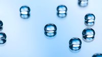 Clear water droplets scattered on clean white surface creating fresh minimalist composition for wellness and purity concepts in commercial design projects.