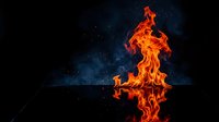 Dramatic orange flames dancing upward with reflection on dark surface against starry night sky background for creative projects.