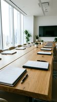 Modern corporate boardroom with long wooden table, documents, pens, and city view through floor-to-ceiling windows, ready for executive meeting.