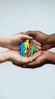 Diverse hands protecting colorful paper family figures symbolizing unity, care, community support, teamwork and social responsibility concepts.