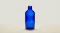 Cobalt blue glass bottle isolated on neutral background, suitable for cosmetics, essential oils, pharmaceuticals, and product packaging design.