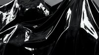 Abstract black glossy plastic material with dramatic folds and reflective surfaces creating dynamic shadows and highlights in monochrome composition.