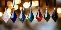 Colorful crystal diamond pendants hanging in row with warm bokeh lights background for jewelry display and decoration.