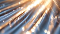 Diagonal rays of golden light with bokeh effect create dramatic abstract background with soft focus and glowing particles for creative designs.
