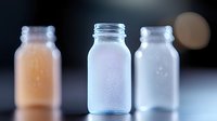 Laboratory glass bottles containing colorful chemical solutions for scientific research and pharmaceutical testing experiments.
