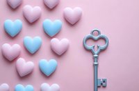 Vintage decorative key and pastel pink and blue heart shapes arranged on pink background. Romantic love concept for Valentine's day cards and wedding designs.