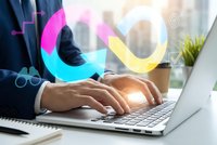 Professional businessman typing on laptop with colorful infinity symbol overlay representing continuous business growth and digital transformation.