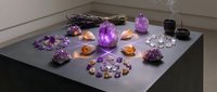 Spiritual healing crystal collection with amethyst geodes, sage bundles and candles arranged on meditation altar for wellness rituals and energy cleansing.