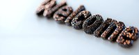 Welcome text spelled with chocolate cookies and sprinkles on white surface, shallow depth of field, sweet food typography for greeting cards and banners.
