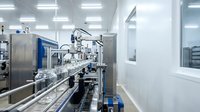 Modern pharmaceutical manufacturing facility with automated production line equipment in sterile cleanroom environment for drug processing and quality control.
