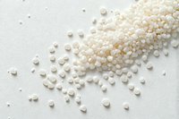 White tapioca pearls scattered on light background, raw dried sago starch balls used in bubble tea and Asian desserts, top view food photography.