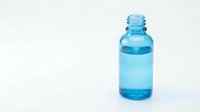 Blue glass essential oil bottle with dropper cap isolated on white background for aromatherapy and wellness product packaging design.