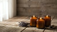 Lit candles in amber glass jars with dried lavender on wooden surface, creating warm ambiance for relaxation, spa, wellness, meditation, and home decor design projects.