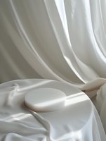 Minimalist white cosmetic product display on luxurious silk fabric with elegant folds and soft shadows creating sophisticated composition for beauty marketing.