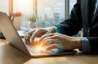 Professional businessman typing on laptop with digital security icons overlay representing cybersecurity, data protection and online safety concepts.