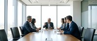 Diverse business team in formal meeting discussing strategy at conference table in modern office with large windows and natural light.