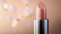 Nude beige lipstick on blurred bokeh background with soft pink and golden lights. Closeup of luxury cosmetic product showcasing modern beauty and glamour.