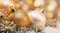 Golden glitter ornament rests on frosted evergreen branches with pearl baubles and warm bokeh lights, perfect for holiday and festive season designs.