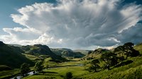 Lush green valley landscape with rolling hills, scattered trees, and dramatic cloudy sky overhead, suitable for travel, nature, and environmental design projects.