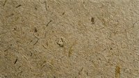 Natural brown recycled paper texture with organic fibers and inclusions for eco-friendly design projects and sustainable packaging materials.